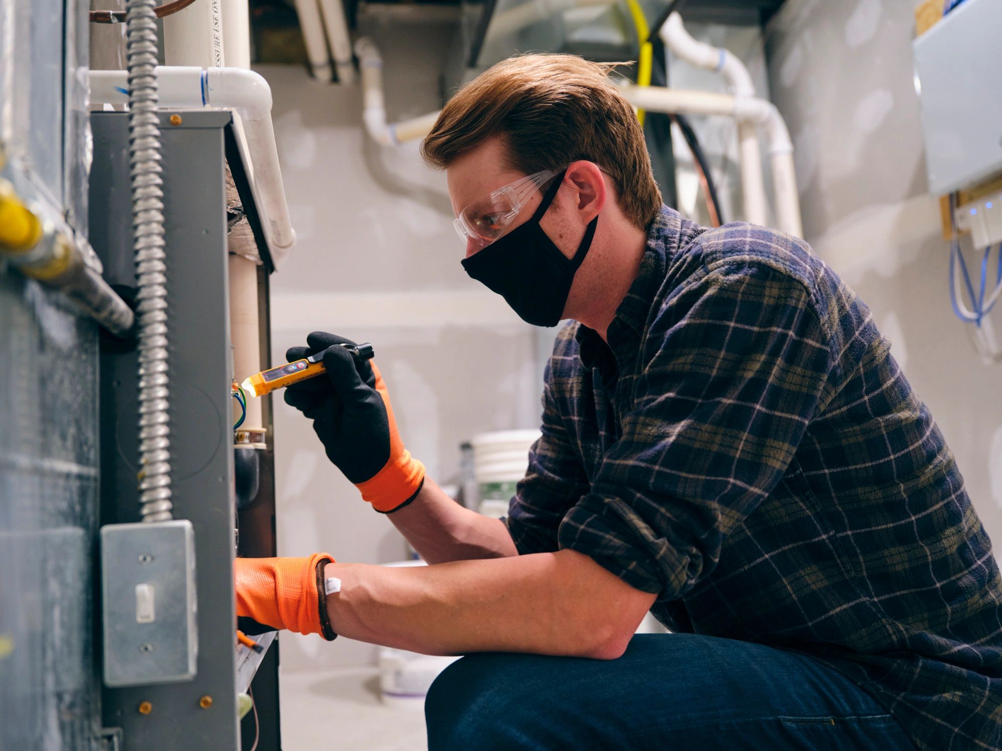 HVAC technician working indoors with protective mask