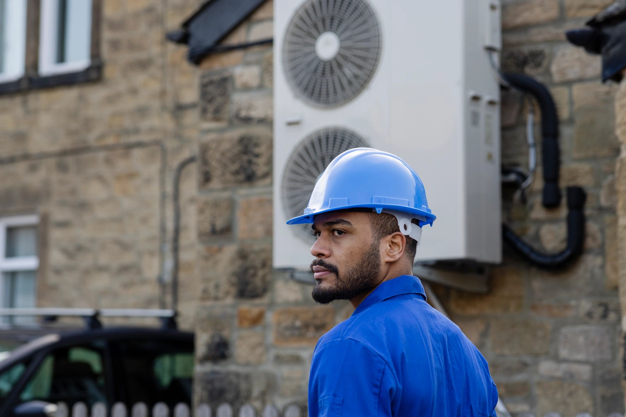Technician installing equipment on the exterior of a home